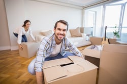 Cute couple unpacking cardboard boxes in their new home.jpeg