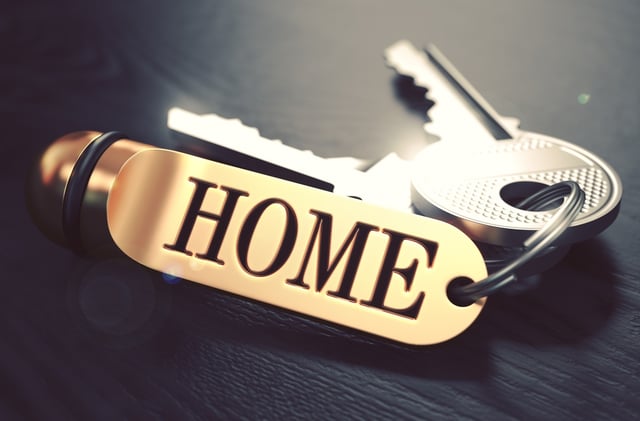 Keys and Golden Keyring with the Word Home over Black Wooden Table with Blur Effect. Toned Image..jpeg