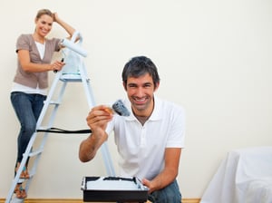 Smiling couple painting a wall of their new house.jpeg