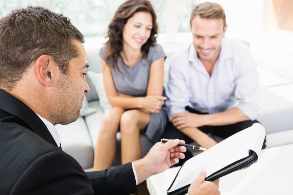 Young couple ready to buy new house interacting with estate-agent.jpeg